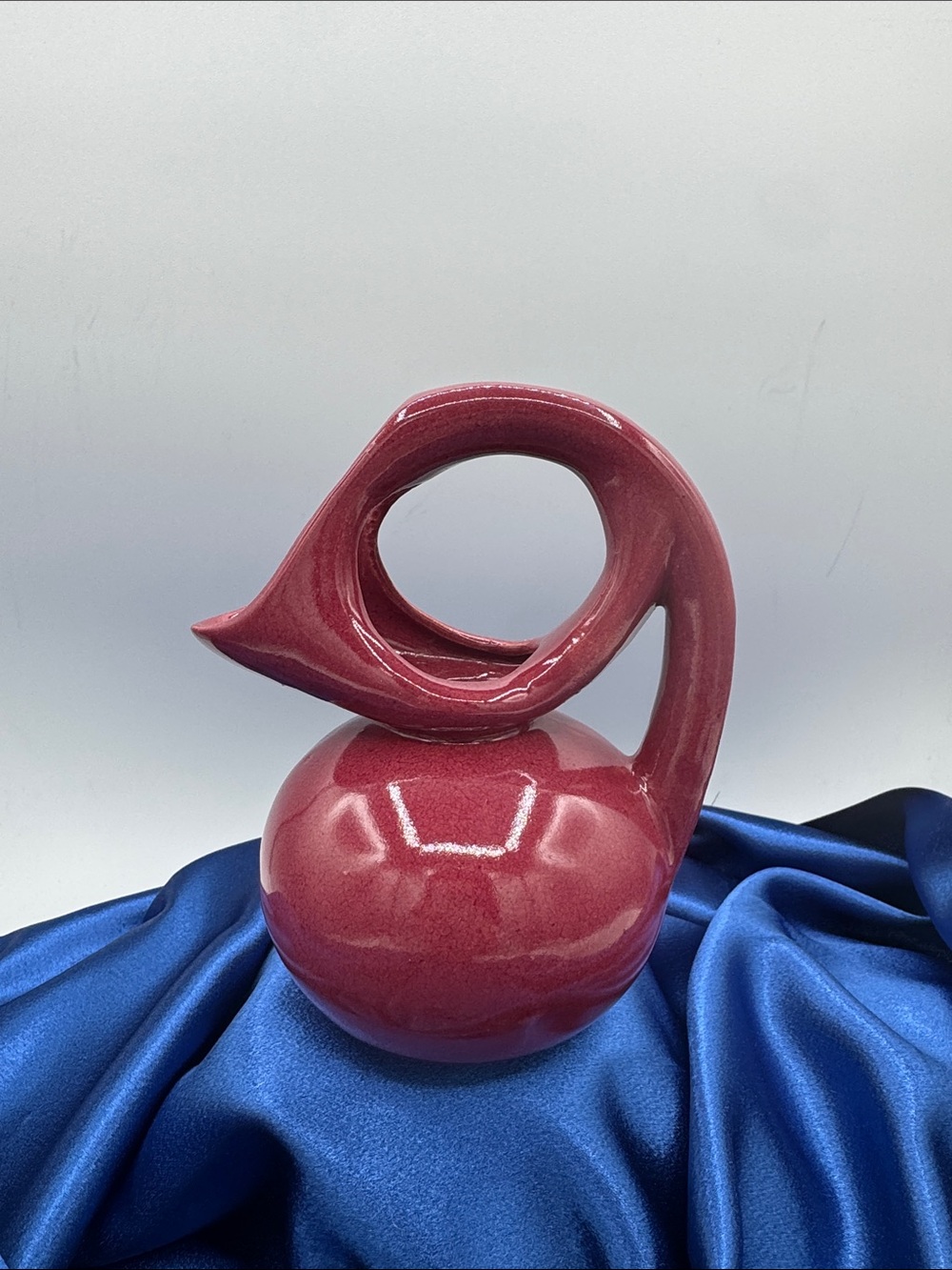 Dryden Pottery pitcher/vase from Kansas, featuring a raspberry or red glaze.